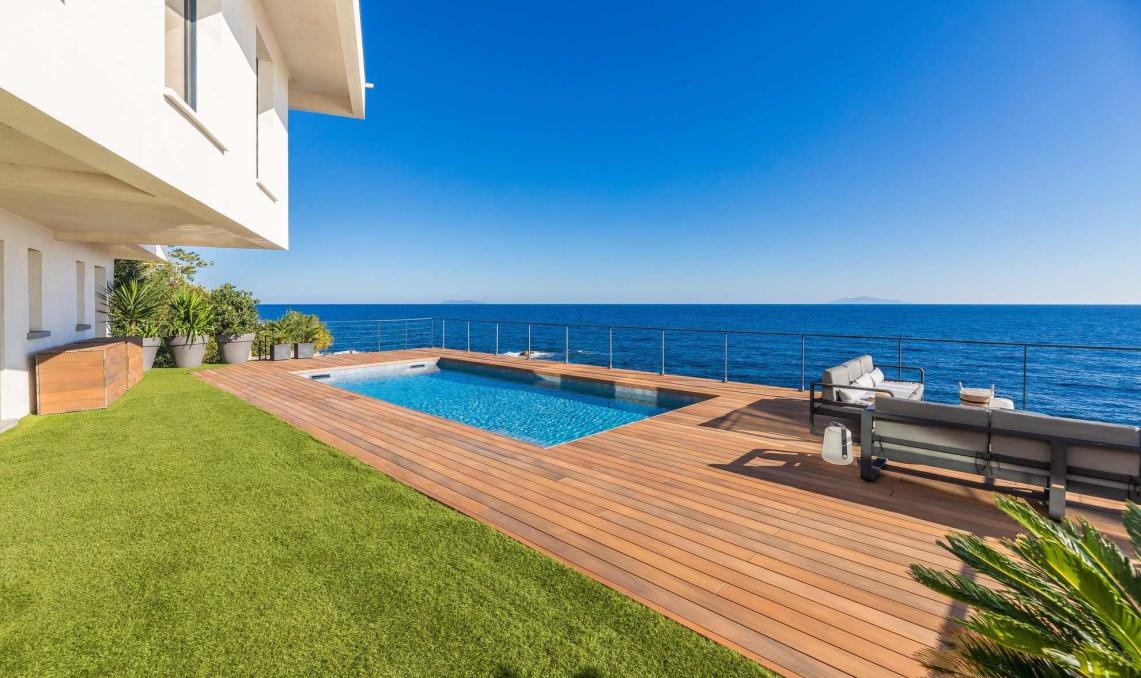 Terrasse en bois composite avec piscine de la Villa Cyrnos en Corse - Aménagement extérieur contemporain avec vue mer et montagne