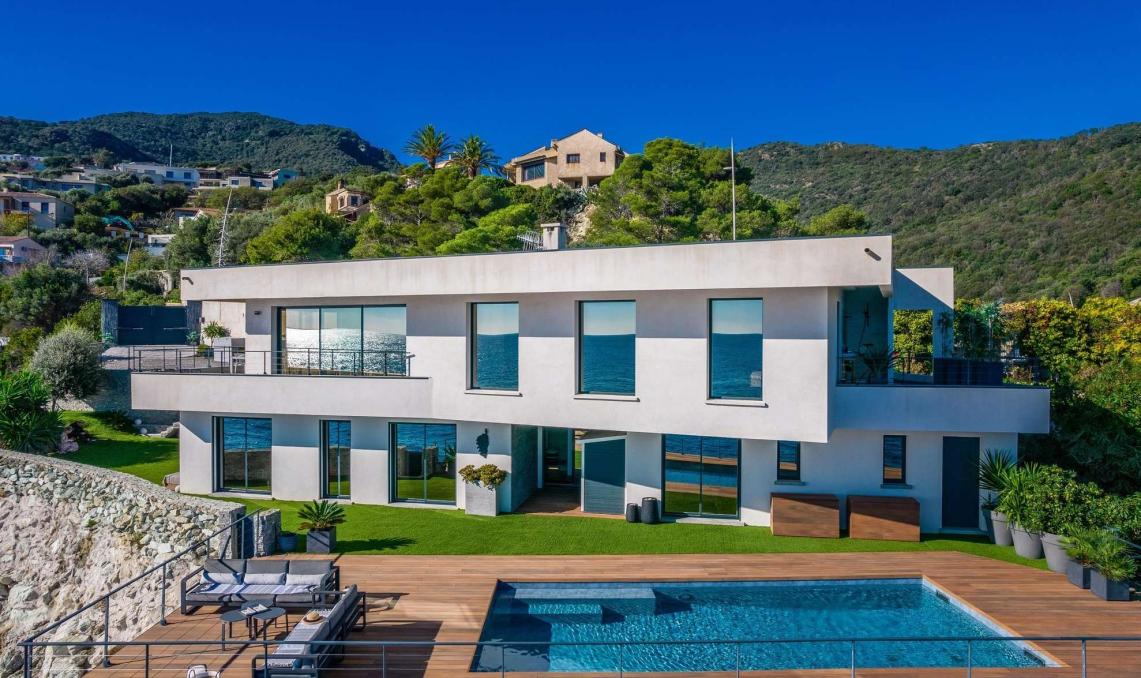 Terrasse en bois composite avec piscine de la Villa Cyrnos en Corse - Aménagement extérieur contemporain avec vue mer et montagne