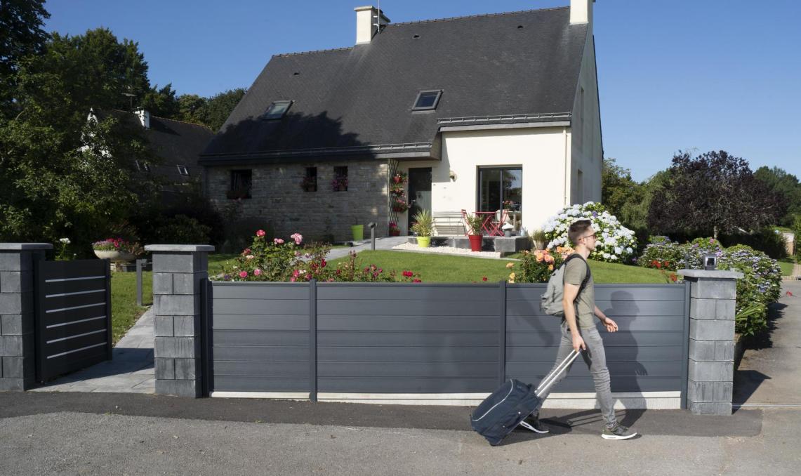 Clôture Atmosphère Silvadec gris anthracite installée devant une maison bretonne avec piliers en pierre et portail moderne