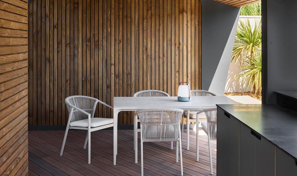 Intérieur pool-house : plancher composite Nuances Ipé, plafond voûté en lames bois, espace repas couvert